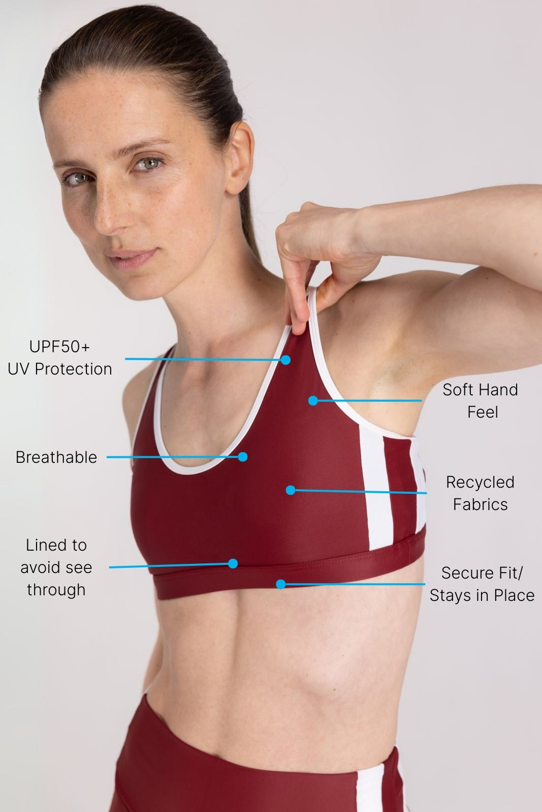 Model adjusting red and white WALLIEN sports top strap after fitness training, for active sessions on white background