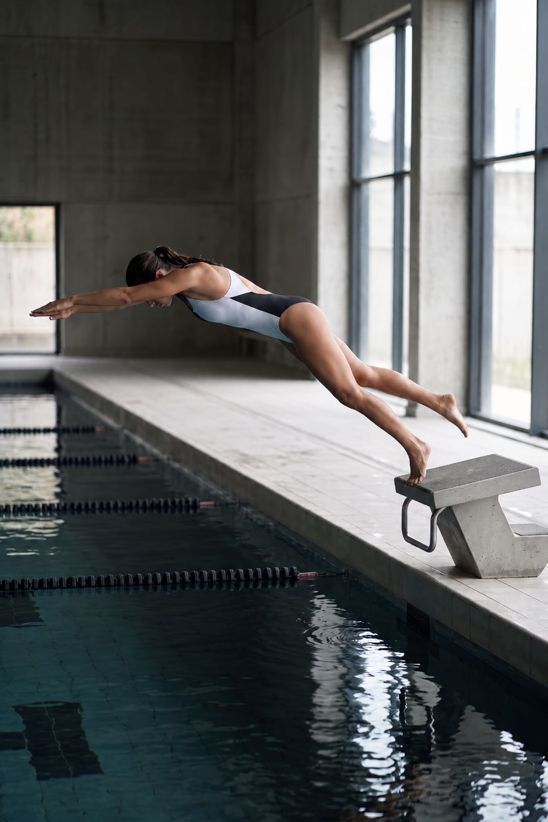Swimmer diving from a starting block in the Liberty Racerback Swimsuit High Cut Black / White