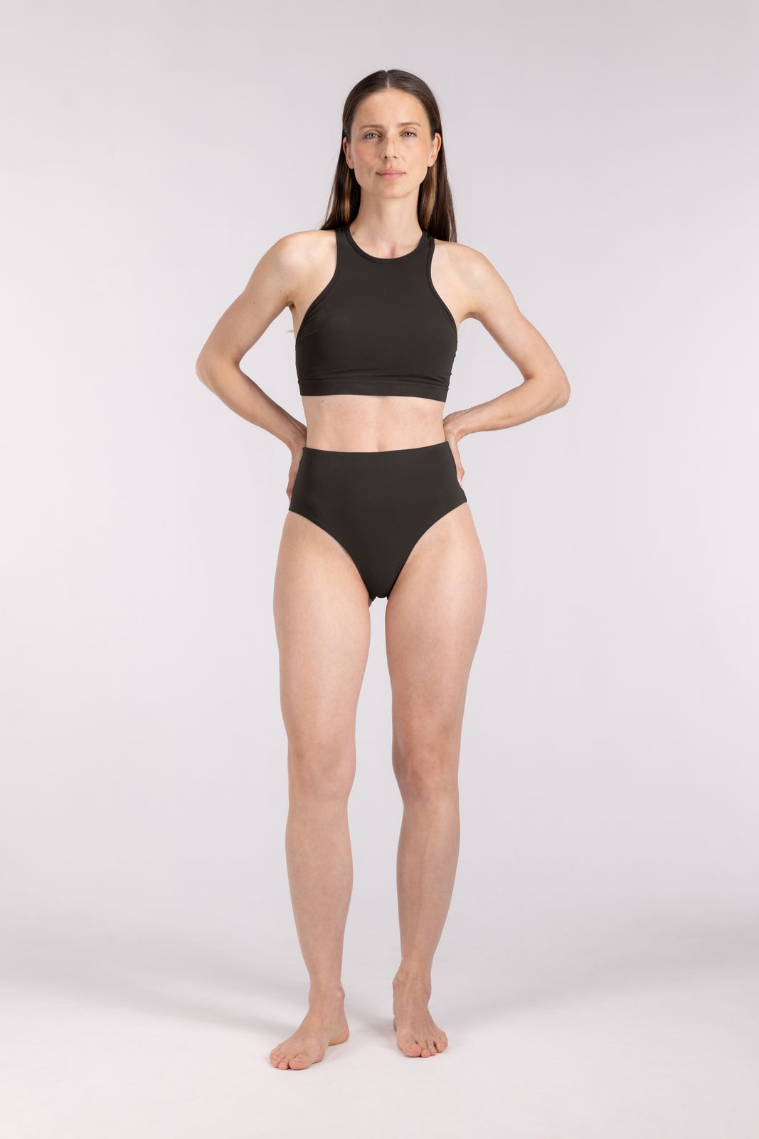 Athletic model in WALLIEN racerfront bikini top and bottom in coffee, designed for active water sports, neutral background