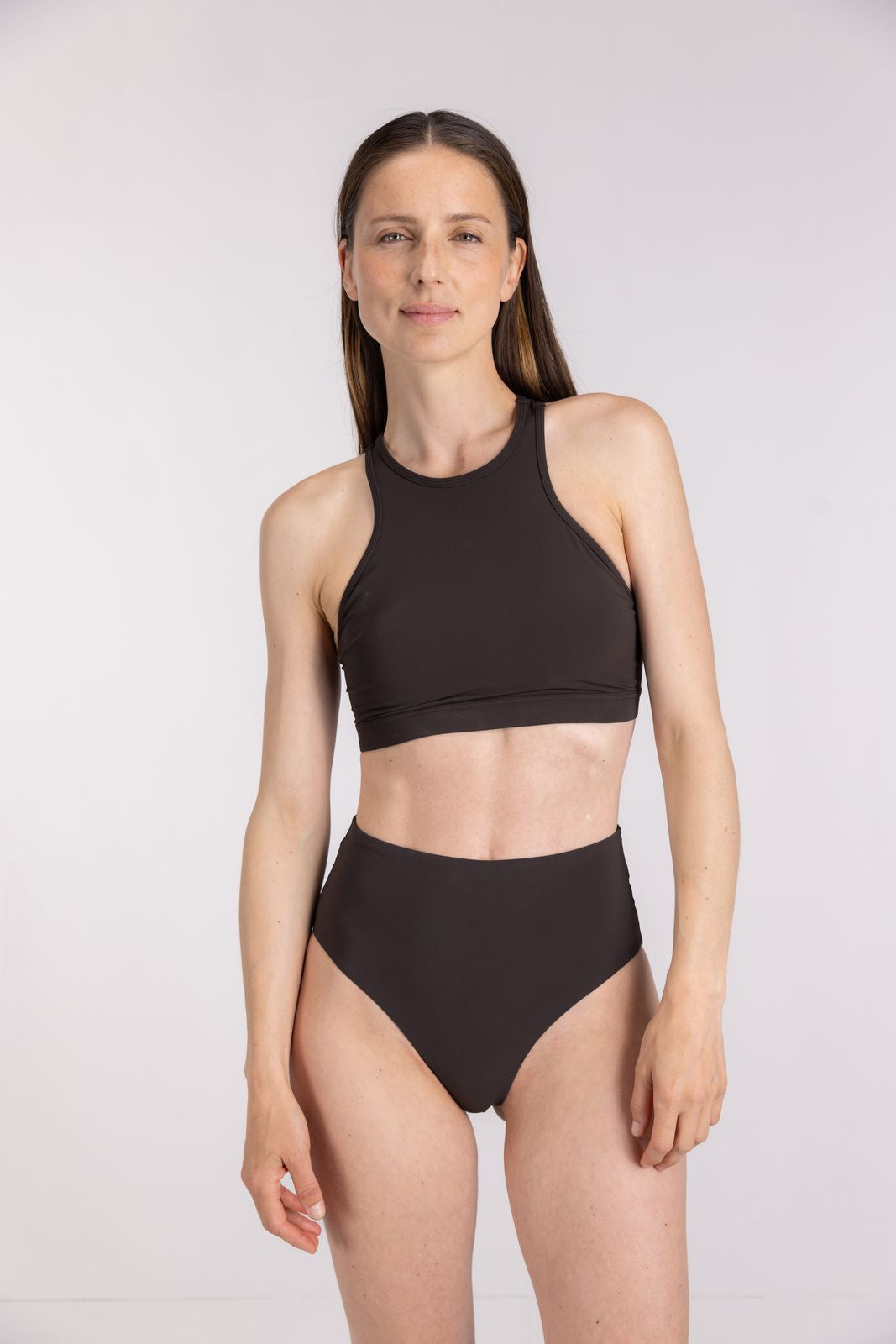 High-waist coffee bikini bottom paired with racerfront top designed for surfing or swimming, on white studio background