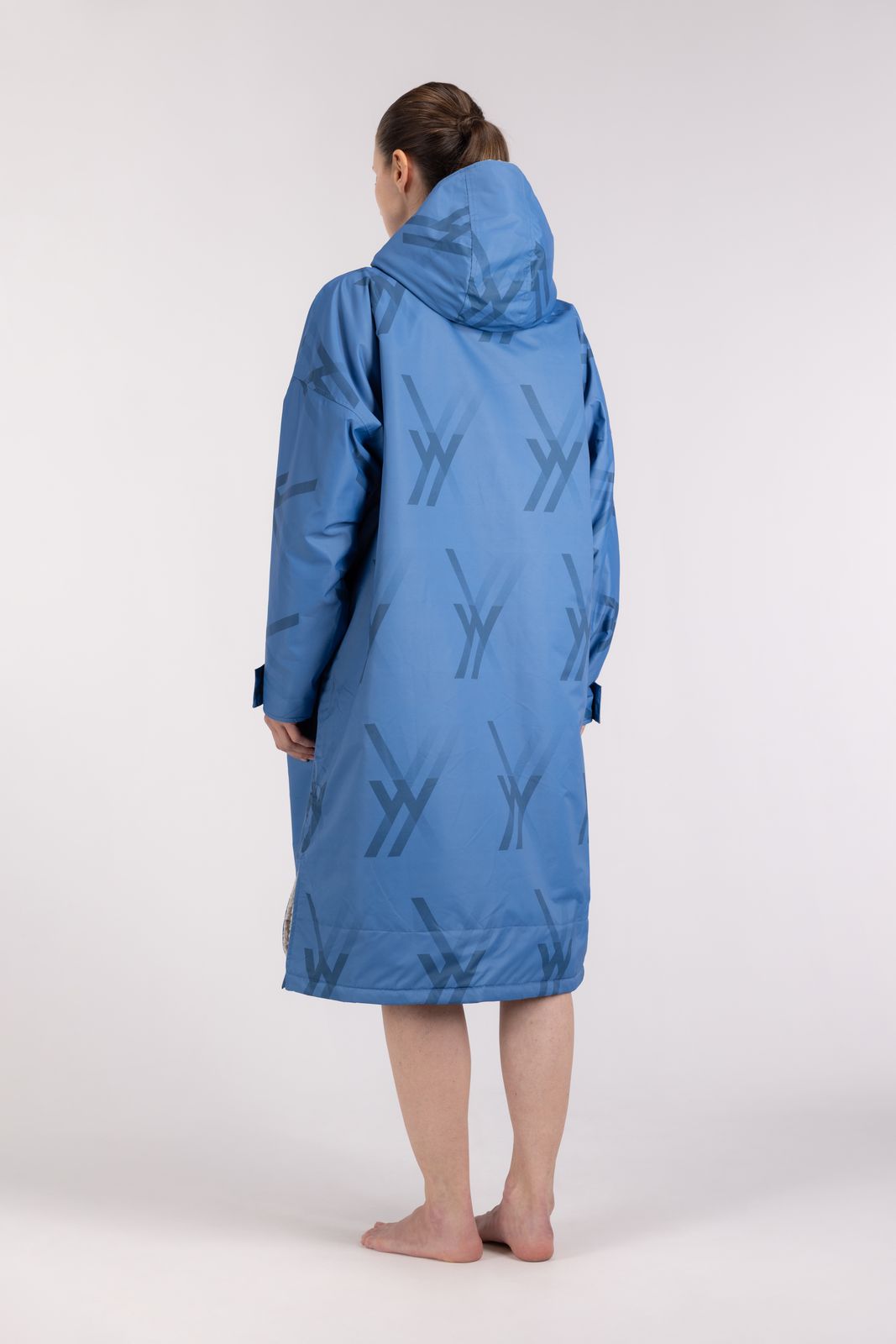 Back view of blue WALLIEN changing robe with hood and signature logo print, arms relaxed, white studio background